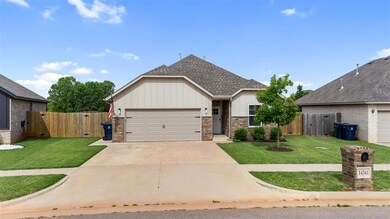 View of front of property with a gate, brick siding, a garage, and driveway