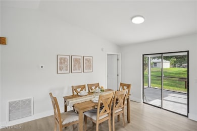 Dining area featuring vaulted ceiling, light wood-