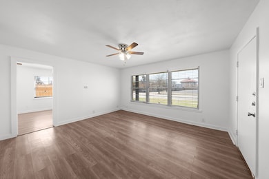 Unfurnished bedroom featuring dark wood-style flooring and a ceiling fan