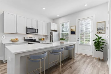 Kitchen featuring a kitchen island with sink, a br