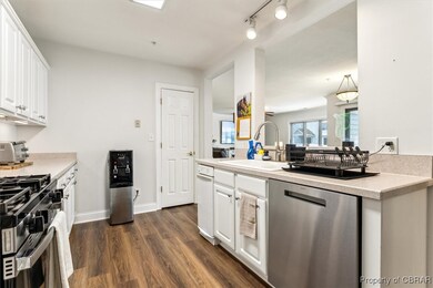 Kitchen with dark wood-style flooring, a sink, sta