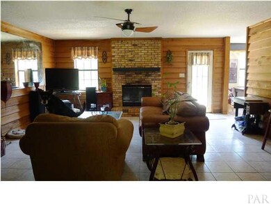 Inside is a comfy country home with fireplace, tile flooring throughout living areas and wood barnboard paneling.
