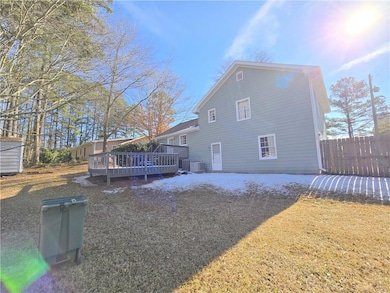 Back of property featuring a wooden deck, a yard, 