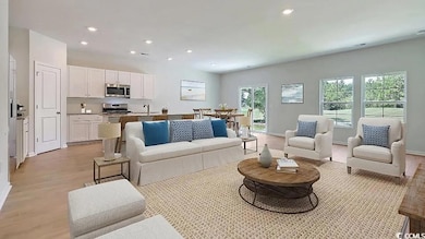 Living room with light wood-style floors, baseboards, and recessed lighting