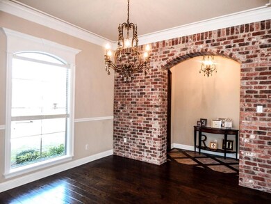 Formal dining with brick wall and archway from foy