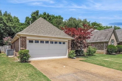 Garage with central AC unit and concrete driveway