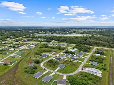 Aerial view of property and surrounding area featuring a nearby body of water and nearby suburban area