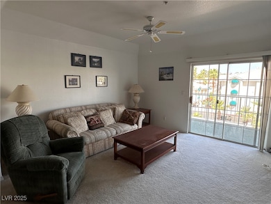 Living area featuring ceiling fan and carpet floor
