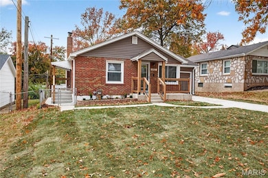 View of front of house with a chimney, a gate, and brick siding