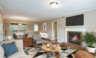 Living room with crown molding, wood-type flooring