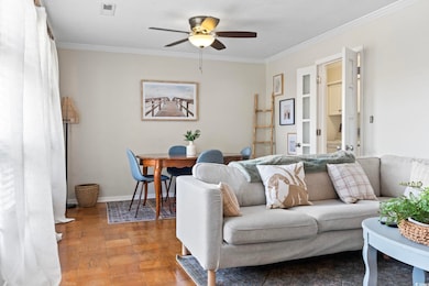 Living room featuring ornamental molding, hardwood