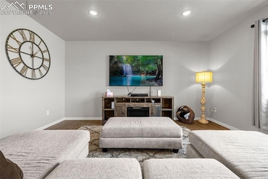 Living area featuring wood finished floors, recessed lighting, and a fireplace