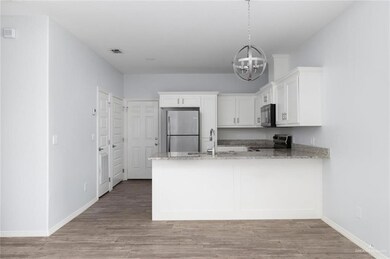 Kitchen with a sink, a chandelier, a peninsula, stainless steel appliances, and visible vents