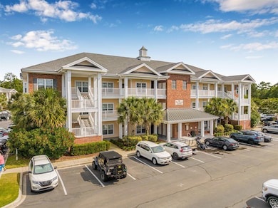 View of property featuring uncovered parking