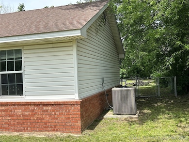 View of side of home with central AC unit, brick s