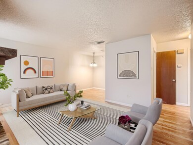 Living area with baseboards, a textured ceiling, 