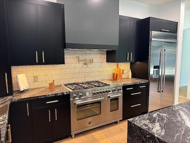 Kitchen featuring dark cabinetry, premium applian