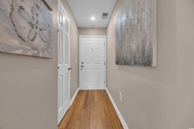 Corridor featuring wood finished floors and recessed lighting