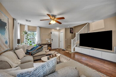 Living room with stairs, wood finished floors, and