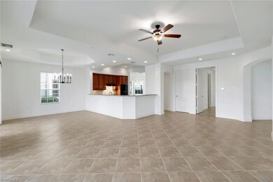 Unfurnished living room with a raised ceiling, lig