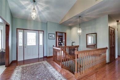 Large entry foyer features a custom-built stairway to the lower level. Pocket doors lead to the office.