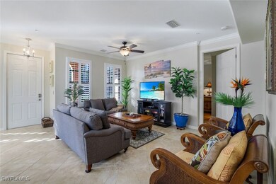 Tiled living room with ornamental molding and ceiling fan with notable chandelier