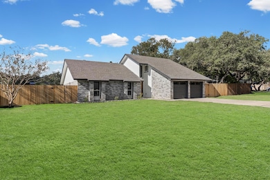 Mid-century inspired home with a shingled roof, concrete driveway, brick siding, and a garage