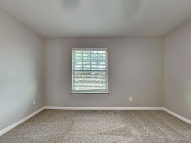 Carpeted empty room featuring baseboards
