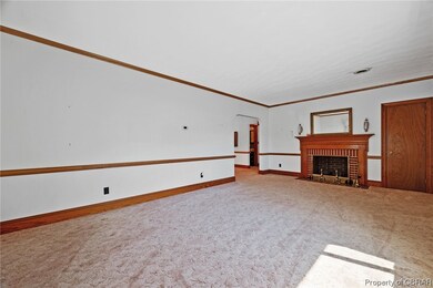 Carpeted living room featuring crown molding and a