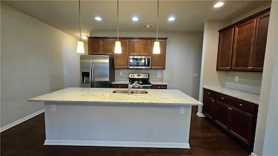 Kitchen with light stone counters, visible vents, 