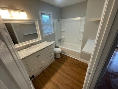 Full bath featuring wood finished floors, vanity, and bathtub / shower combination
