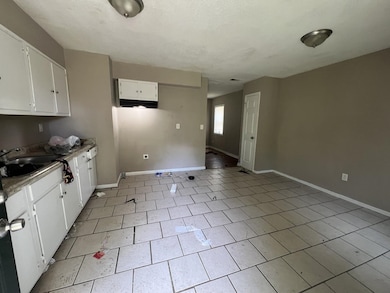 Kitchen featuring white cabinets, light countertops, and light tile patterned flooring