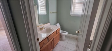 Bathroom with vanity, light tile patterned floors, and healthy amount of natural light