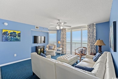 Living room with ceiling fan, carpet flooring, and