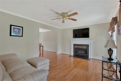 Family room with wood floor, ceiling fan, crown mo