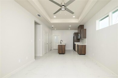 Unfurnished living room with light marble finish floors, baseboards, ceiling fan, recessed lighting, and a sink
