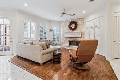 Living room featuring ornamental molding, light tile patterned floors, a stone fireplace, ceiling fan, and recessed lighting