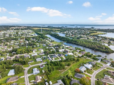 Aerial view of property and surrounding area featuring nearby suburban area and a nearby body of water
