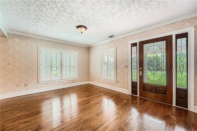 Entrance foyer with crown molding, wood finished floors, plenty of natural light, and a textured ceiling
