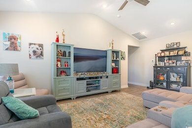 Living room featuring ceiling fan, light hardwood 