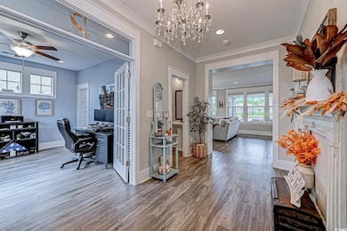 Office space featuring wood finished floors, ornamental molding, a chandelier, recessed lighting, and ceiling fan