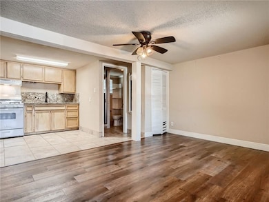 Kitchen featuring ceiling fan, light brown cabine