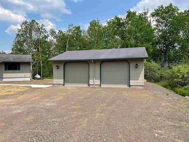 Detached garage with view of scattered trees