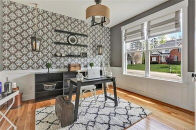Study with hardwood floors, picture frame moulding, Crown, Wall paper accents and floating shelves.