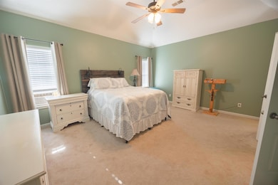 Bedroom with multiple windows, light colored carpe