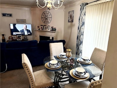 Dining space with carpet, ornamental molding, and 