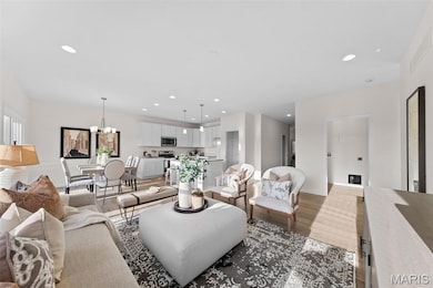 Living room featuring dark wood-style flooring, recessed lighting, and a chandelier