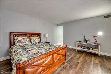 Bedroom with dark wood-style floors and baseboards