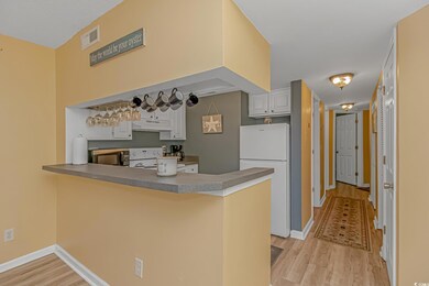 Kitchen with light wood-type flooring, white appli