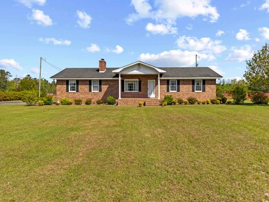 Single story home featuring a chimney, a front law